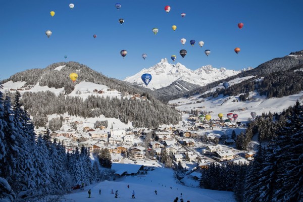 Skipiste mit Sicht auf Heißluftballone bei den Ballonwochen in Filzmoos © Coen Weesjes